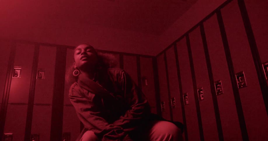 A black girl strikes some poses in front of a bank of lockers