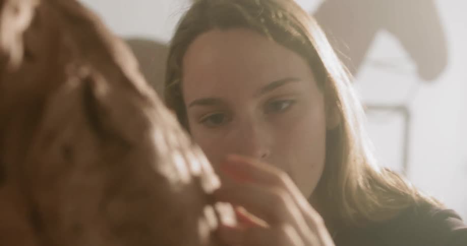 Woman rubs her hand on a piece of artwork