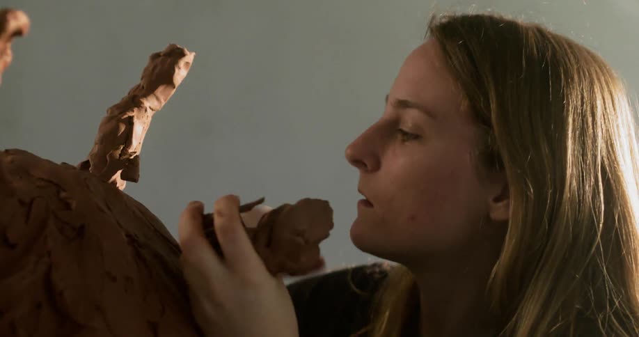 A woman is carving a statue