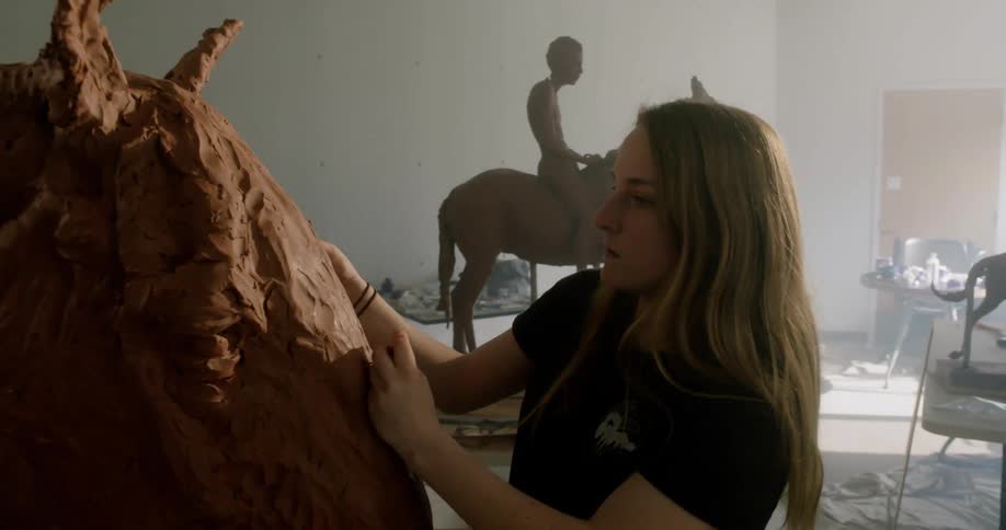 A woman sculpts with clay