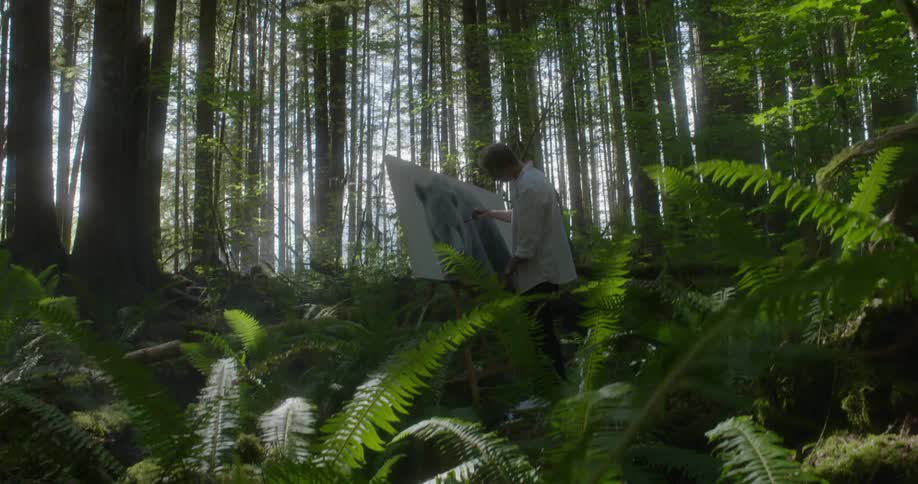 Man paints a picture of bear in the dense forest
