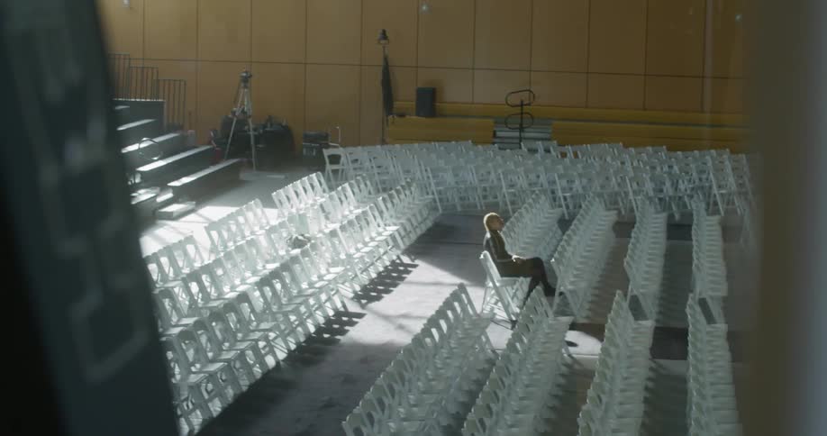 A room is set up with chairs and one person sits in them