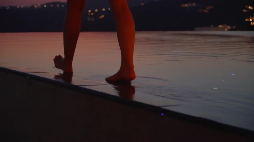 A woman walks next to the pool