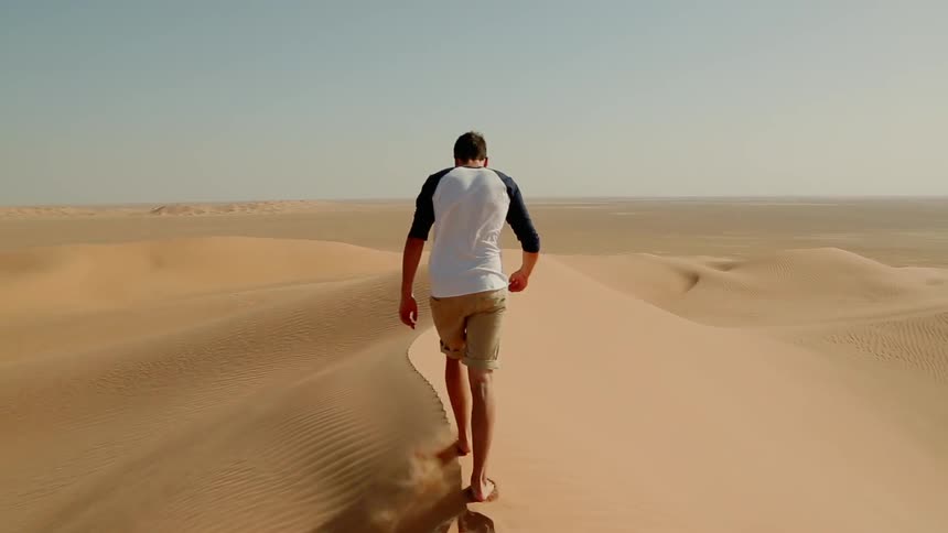A man walking in a sandy desert