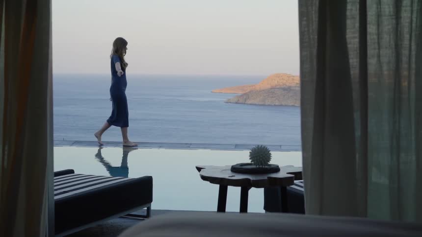A woman is walking on the ledge near her home