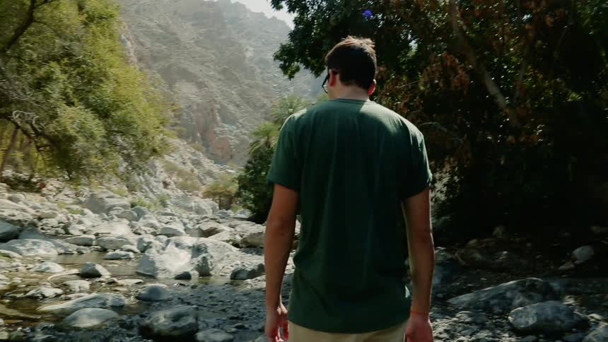 A man stops hiking near a creek to take in the scenery