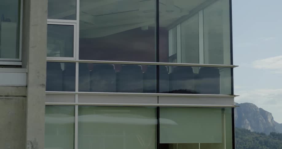 A mountain range lies behind a modern looking office building