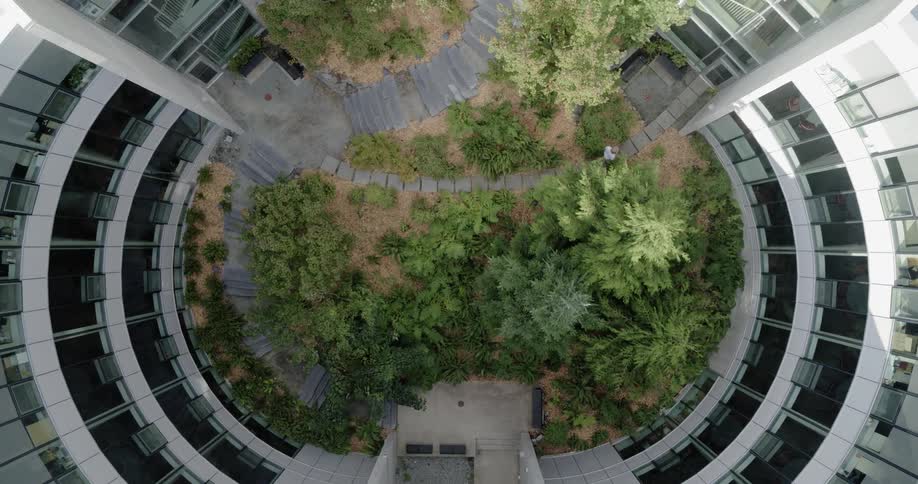 An aerial view of a person walking into a building is displayed