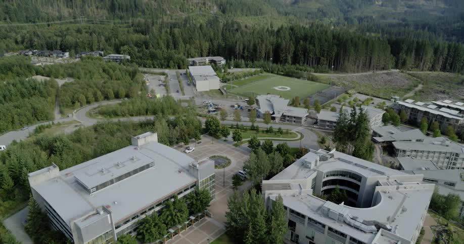 Many buildings sit near the green mountains