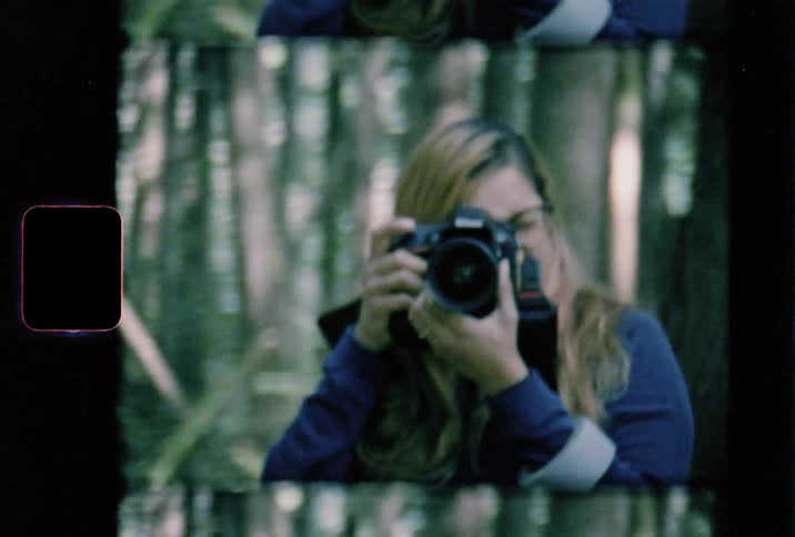 Film footage of a white woman taking pictures