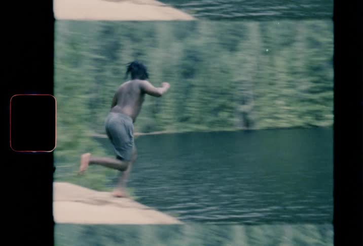 Vintage footage of a person running into a lake
