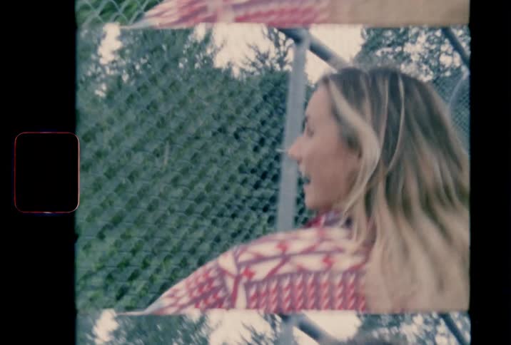 Two woman walk through a fenced bridge