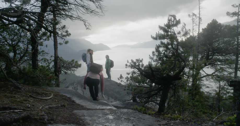 Friends gather on the rocks of a mountain