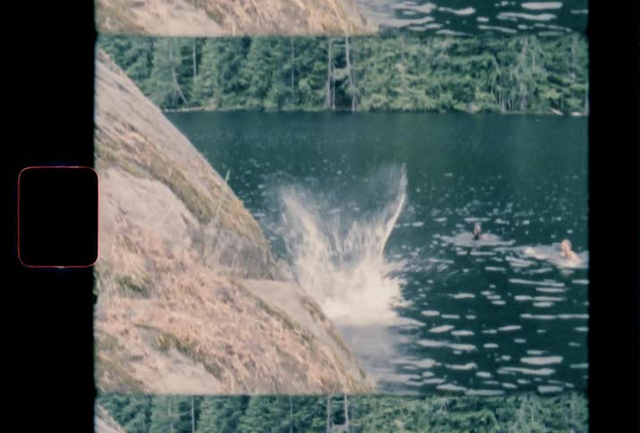A woman jumps off a rock into a lake with a big splash