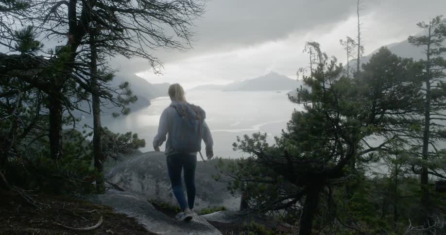 A young girl hikes across some rocks