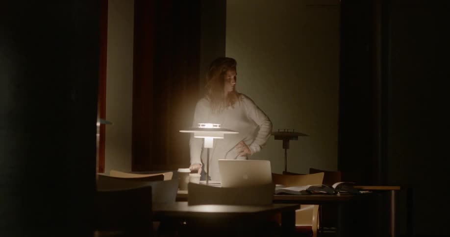 A woman takes a drink at the table in the hall