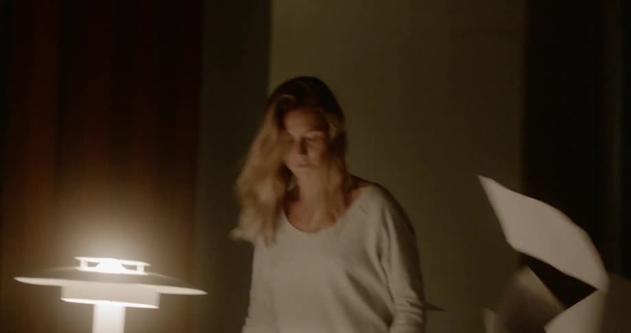 An angry woman throws papers off a desk in frustration