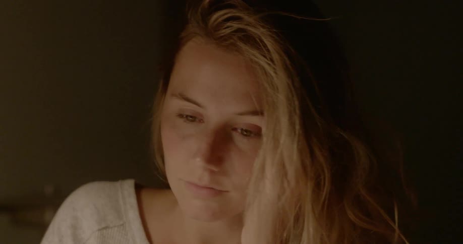 A woman wakes up after falling asleep at the desk