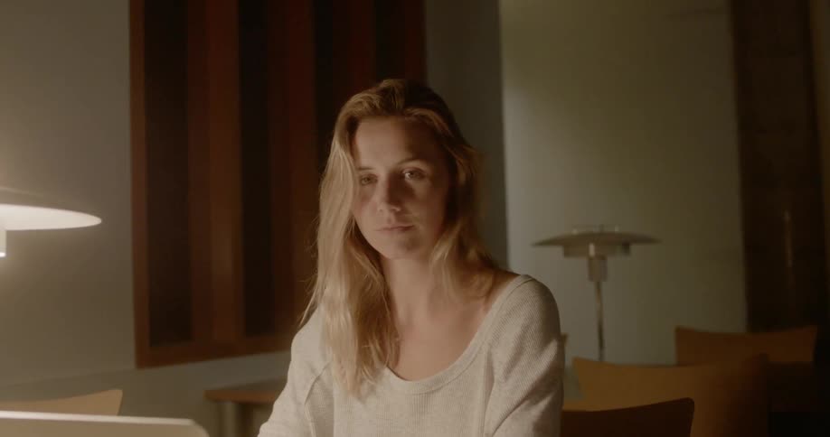 A woman is sitting at the desk in the room