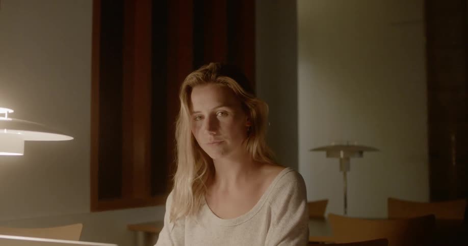 A woman looks away from the laptop