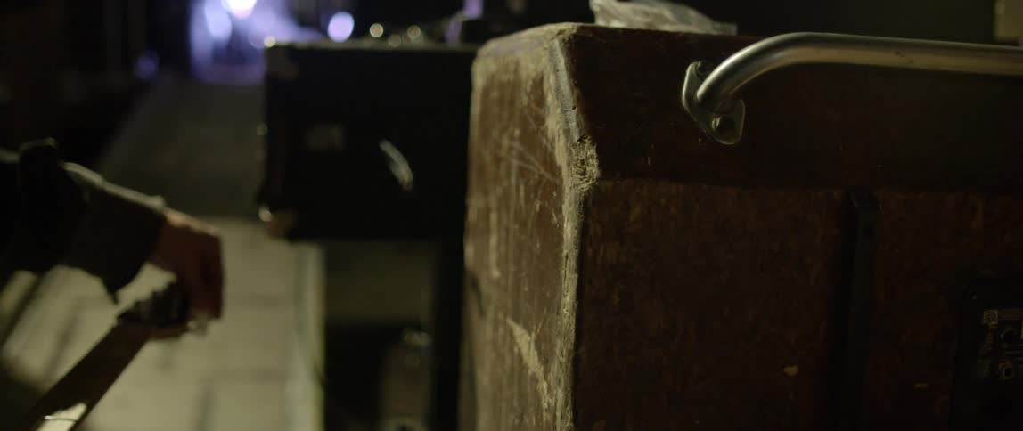 A persons hand tuning a guitar with a ramp in the background