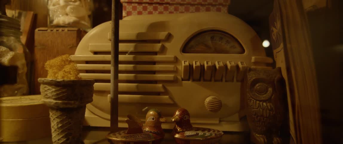 A shelf is covered with knick knacks including a retro style radio and an ice cream cone