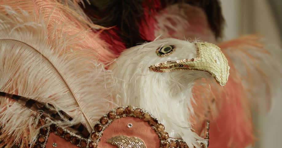 A costume hat with a decorative bird with beads on it