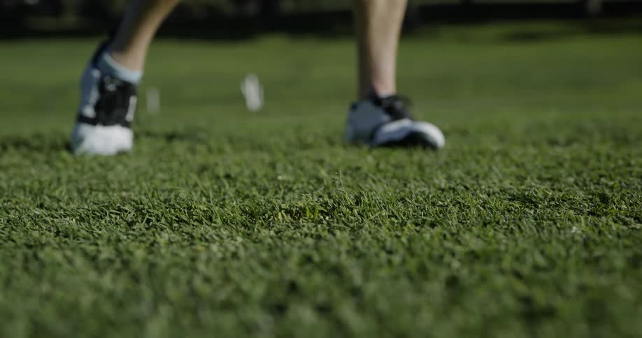 A person is swinging a golf ball outside