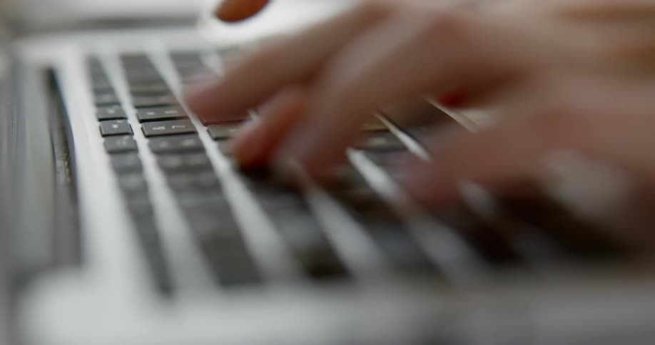 Person types on a laptop keyboard