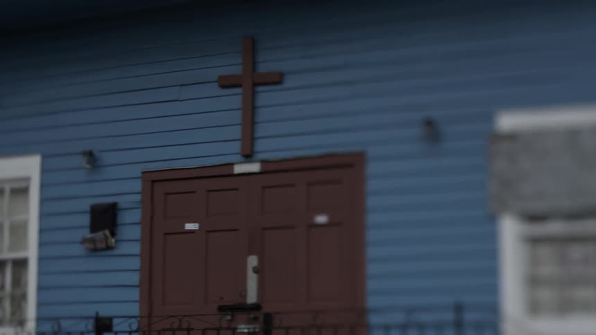 Driving pass a small church with blue siding