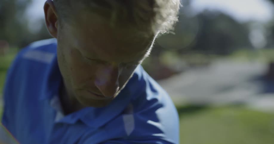 Blonde man plays golf on a sunny day