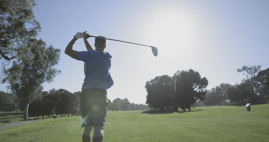 Golf player uses a club to hit the ball into the hole on a course