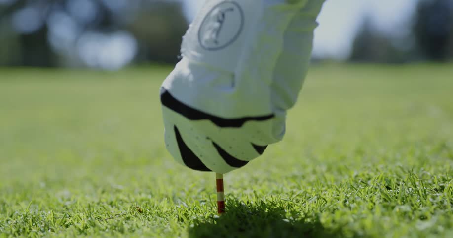 Man adjusts tee and golf ball