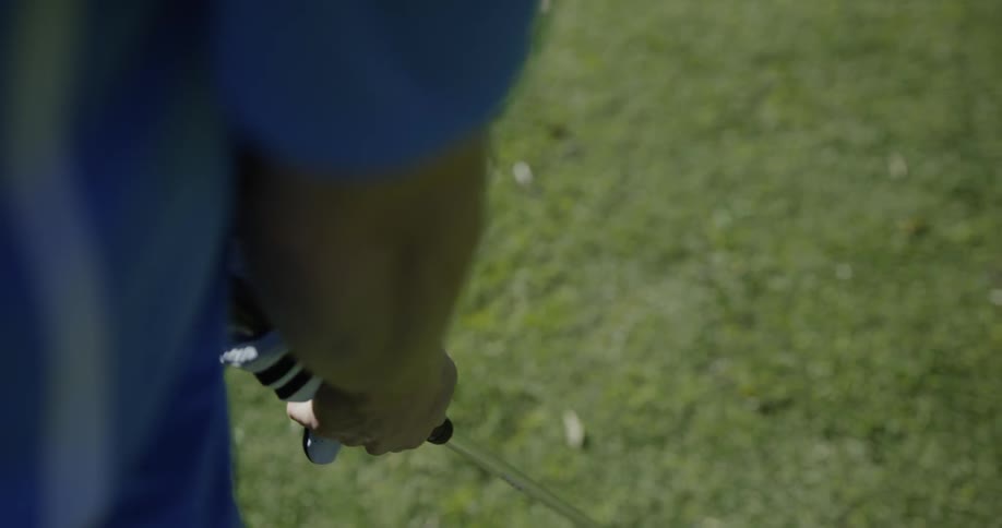 Golf player puts on glove and hits the ball with the club on the course