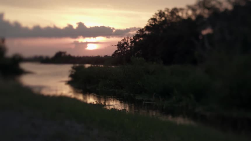 The sun is setting in the distance behind a body of water
