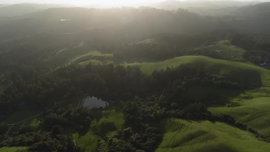 The sun is shining over the hills below