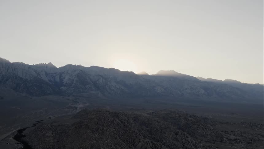 A rocky mountain ridge over a barren landscape