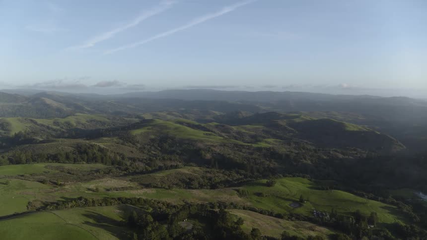 A hilly terrain with trees land and small lakes