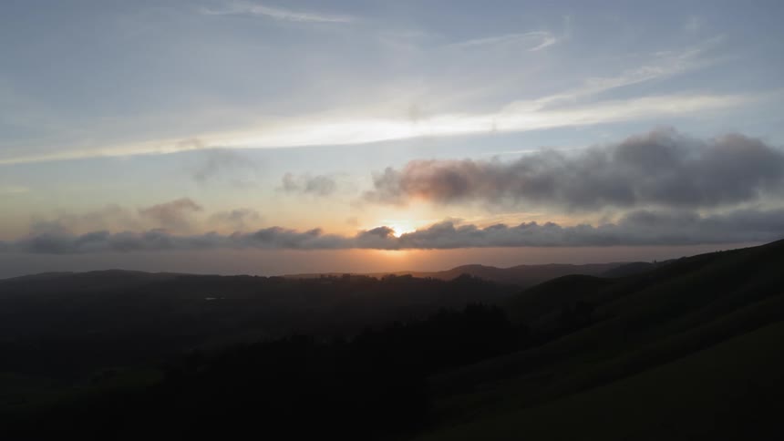 Scenic view of the sunset through the clouds across the lake