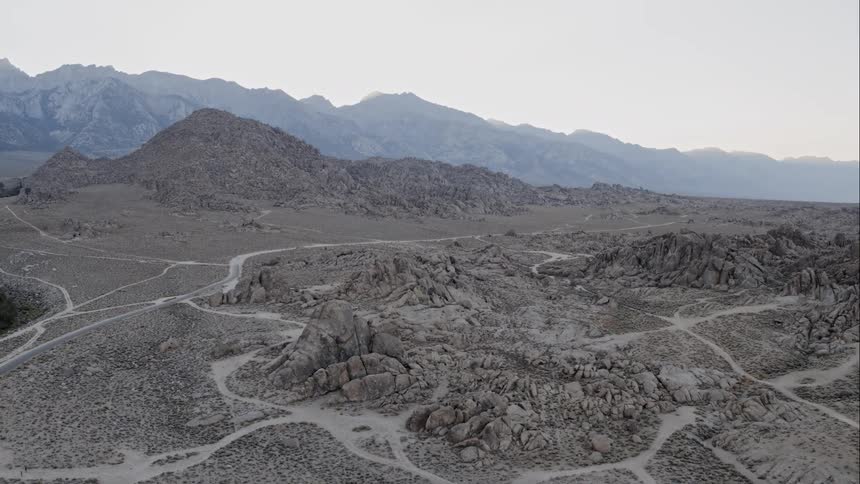 A gray and rocky landscape laced with muddy streams