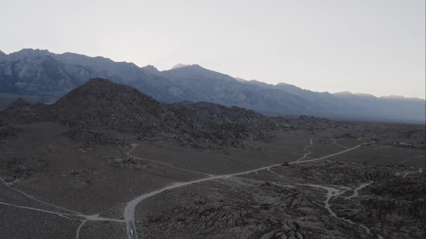 Landscape view of barren land with mountains in the background