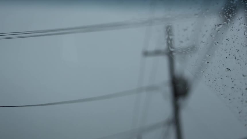 Looking out the windshield of a moving vehicle as the wipers wipe away the rain