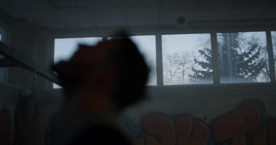 Man stands with his head looking up in the gym on a cloudy day