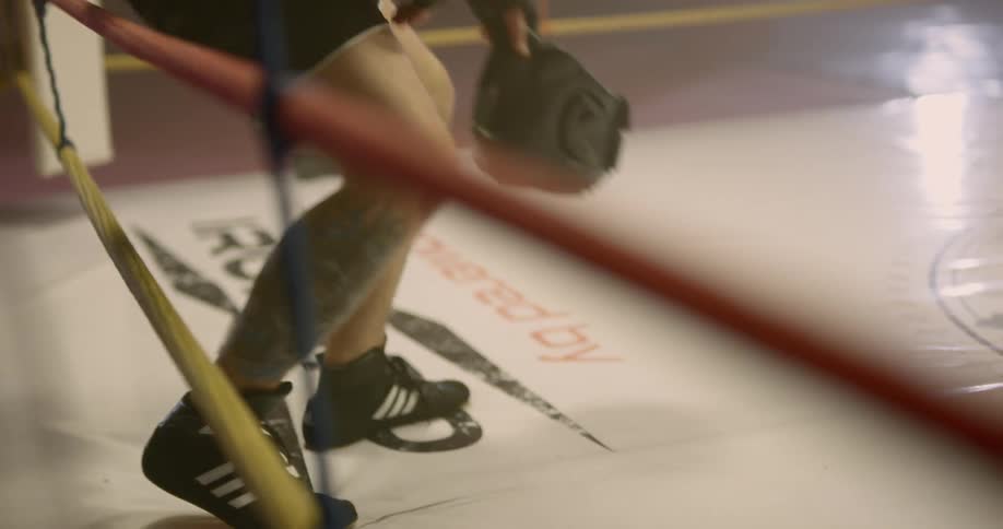 A man knees and breathes hard after a boxing match