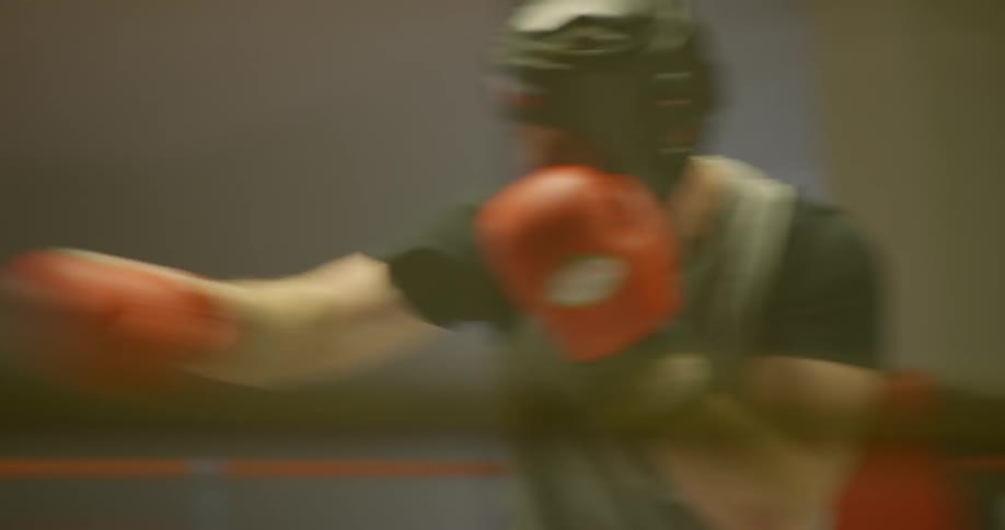 Two boxers train and hit each other in the boxing ring