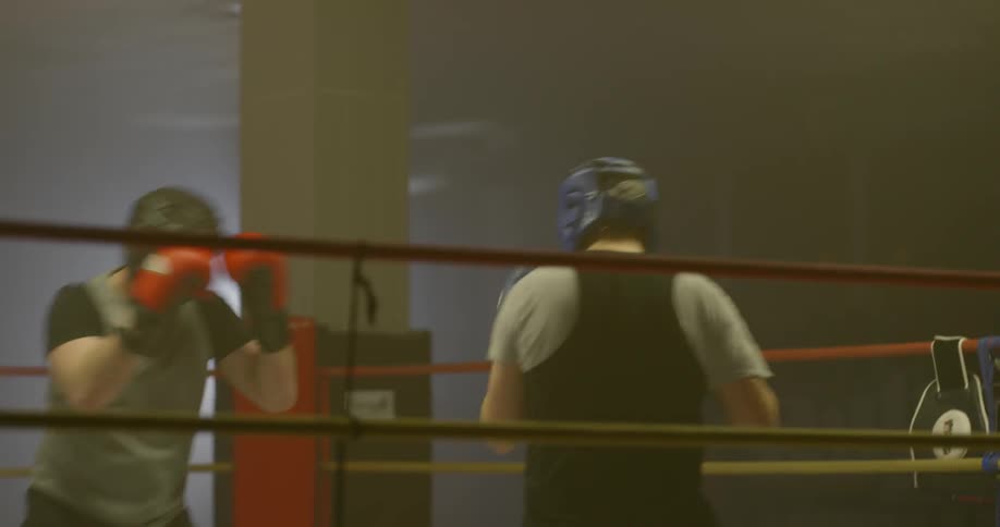 Men boxing indoors in a ring