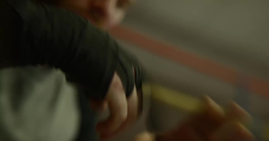 A man takes tape off of his wrapped hand