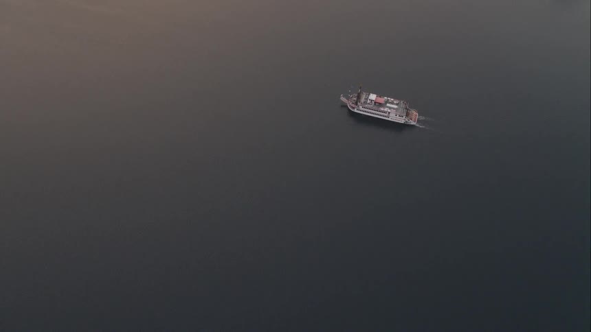 From high above a large steamboat can be seen paddling along a large body of water