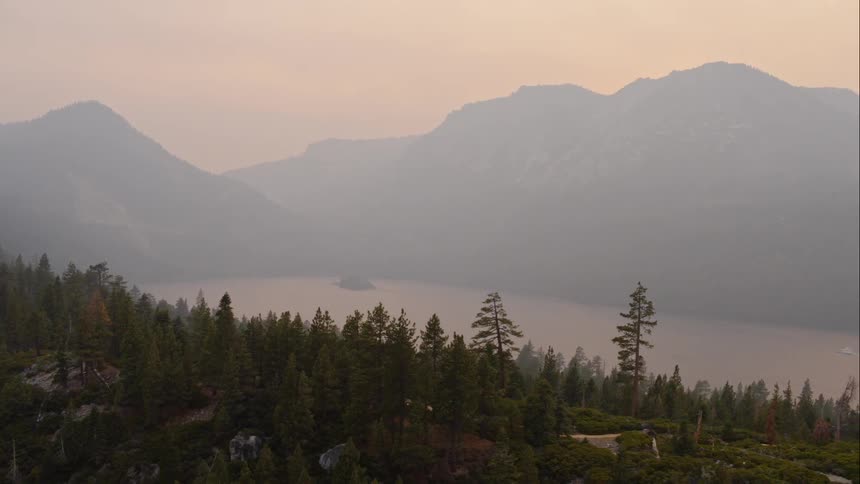 Aerial view of big mountain range next to the lake at dawn
