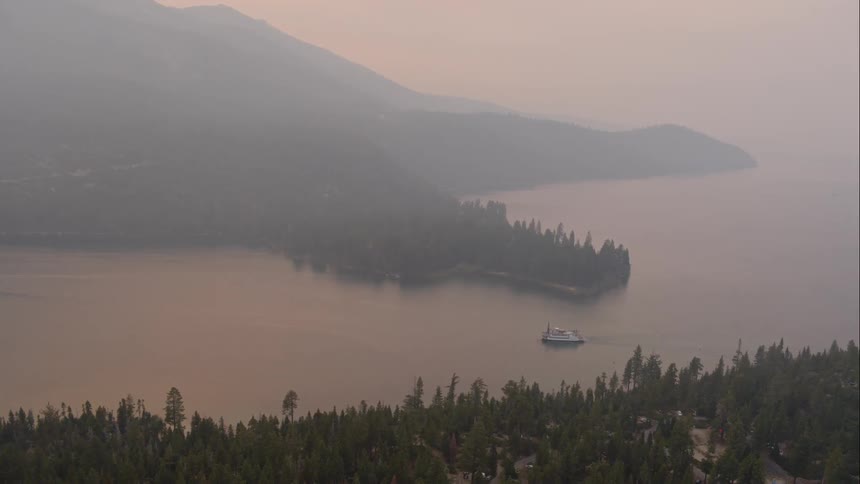 A boat is slowly traveling along the shore